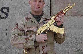 An american G.I (Marine or Army) poseign with Saddams AK-47.