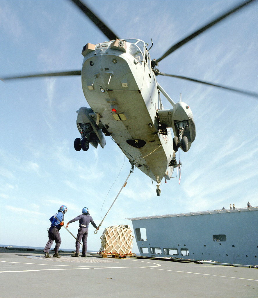 Sea King helicopter doing VERTREP (Vertical Replenishment at Sea).