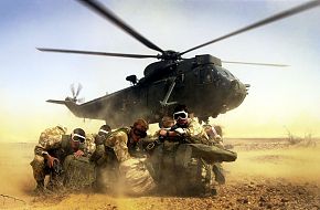 Royal Marines from 40 Commando go into a huddle as the Royal Navy Seaking h
