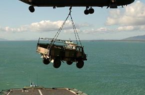 Australian Army Chinook helicopter lifts UNIMOG off an RAN ship.