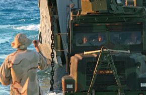 A naval beach master guides a 7-ton truck
