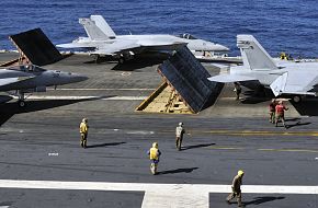 Sailors aboard aircraft carrier ready F/A-18 strike fighters