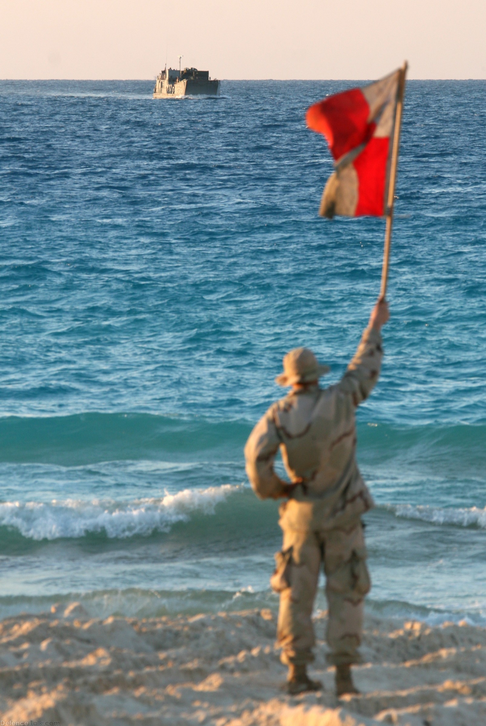 A naval beach master guides a landing craft