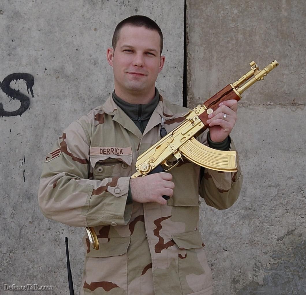 An american G.I (Marine or Army) poseign with Saddams AK-47.
