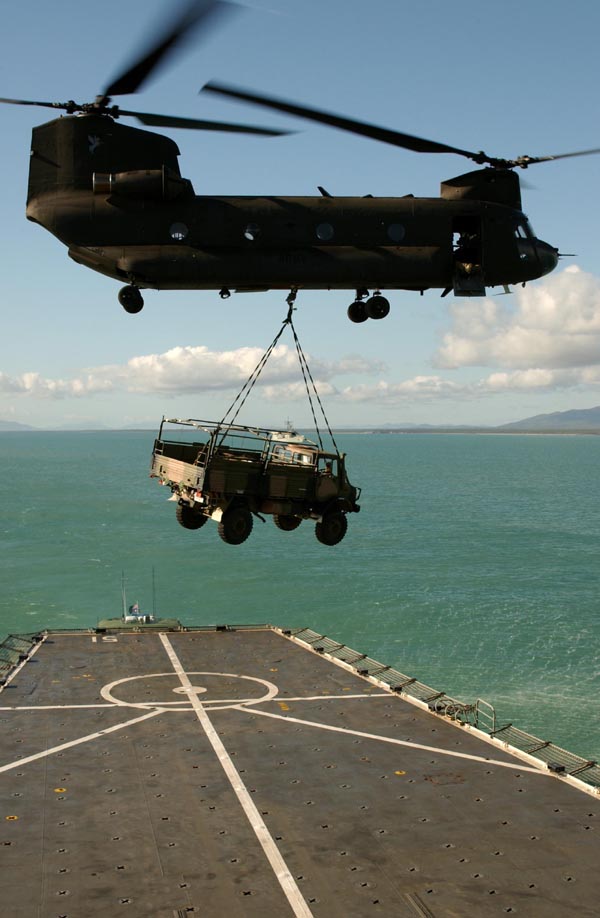 Australian Army Chinook helicopter lifts UNIMOG off an RAN ship.