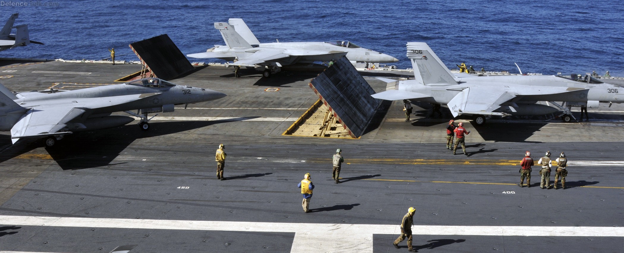 Sailors aboard aircraft carrier ready F/A-18 strike fighters