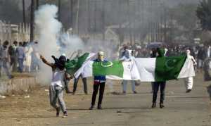 Masked Kashmiris hold the national flag of Pakistan during a protest 